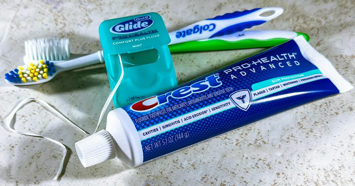 Close-up of dental care items including toothbrush, floss, and toothpaste for oral hygiene.