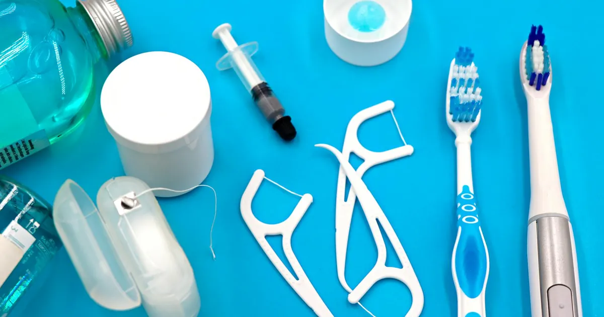A variety of dental hygiene tools arranged neatly on a vibrant blue surface, showcasing oral care essentials.