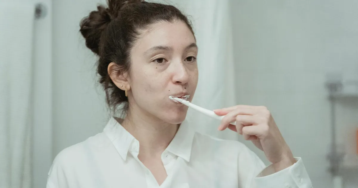 Young woman practicing dental hygiene by brushing her teeth in the morning.