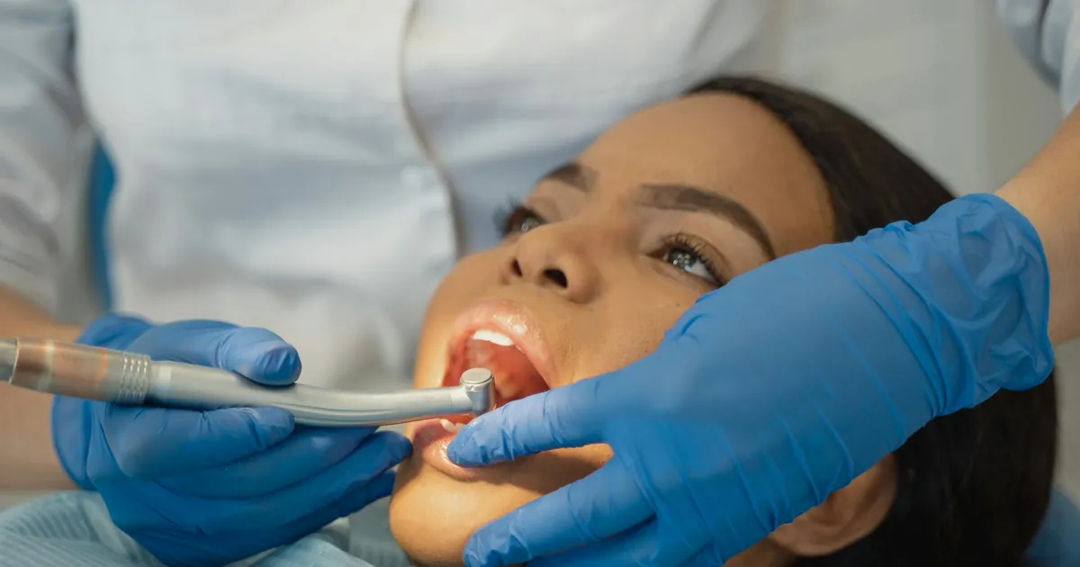 Close-up of a dentist performing a dental treatment on a patient.