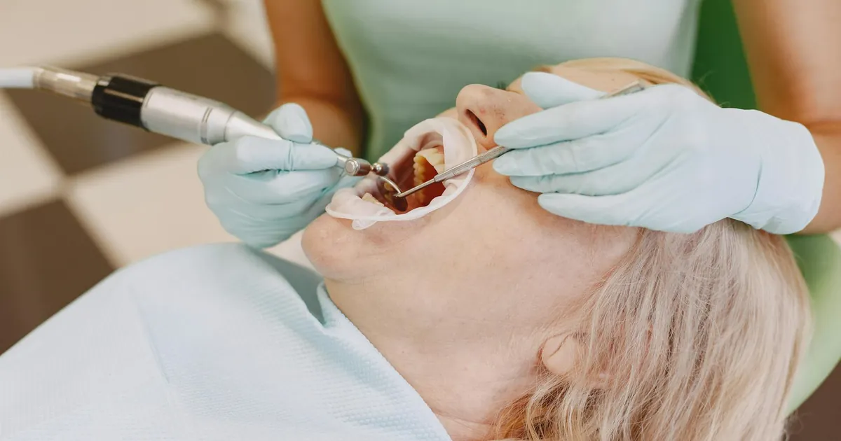 Close-up of a dentist performing a dental procedure on a patient in a clinic.
